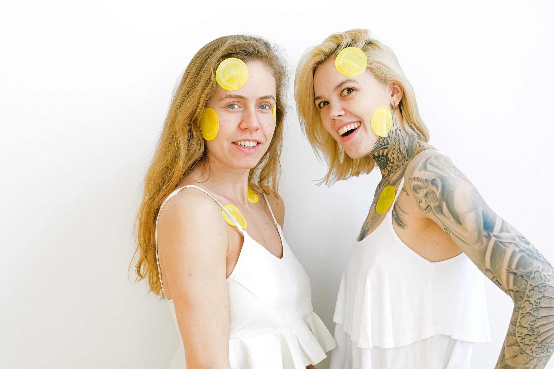 Blue suction vibrator surrounded by flowers and orange slices on yellow background