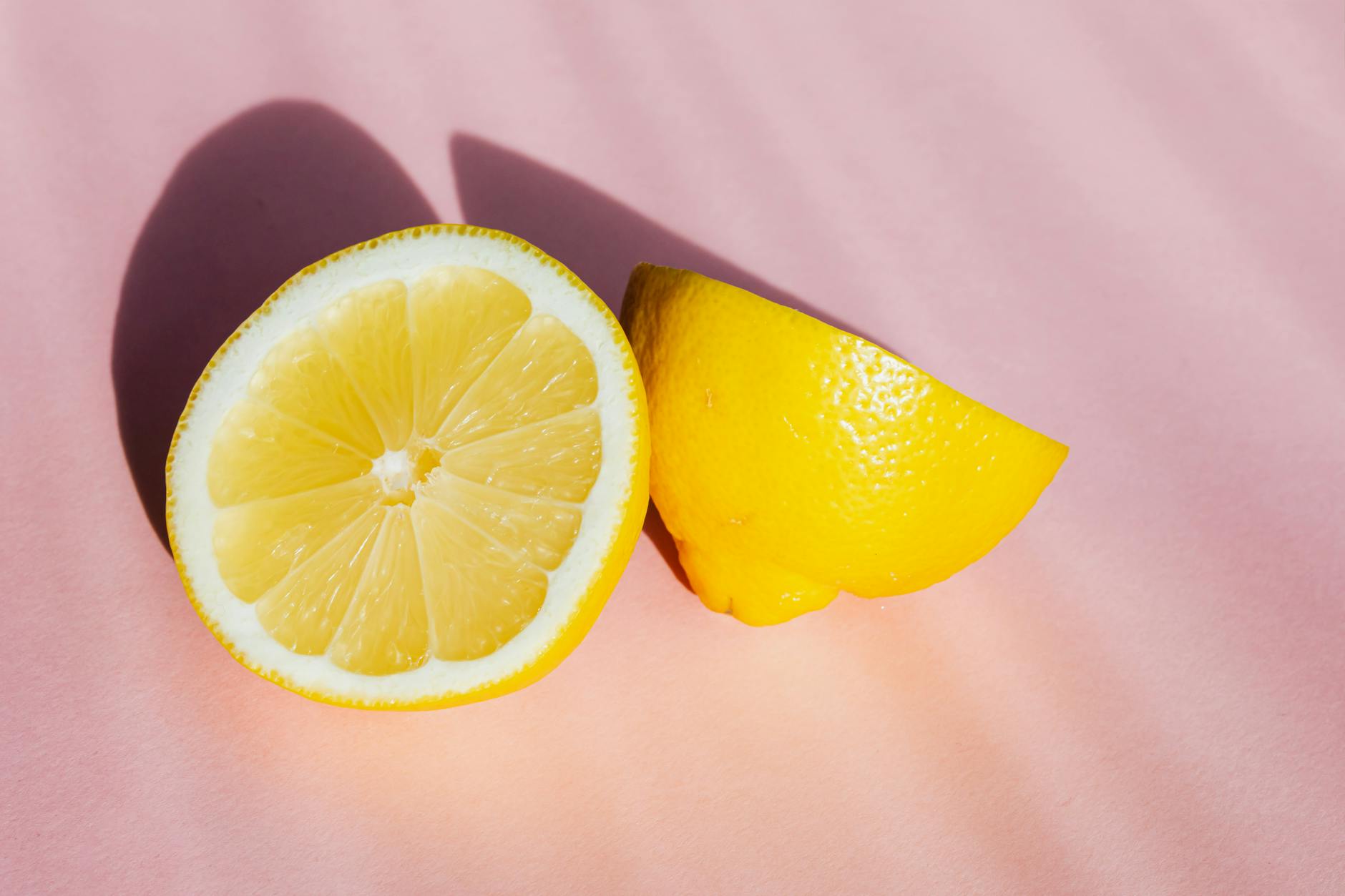 Fresh lemons on a pink background in natural sunlight