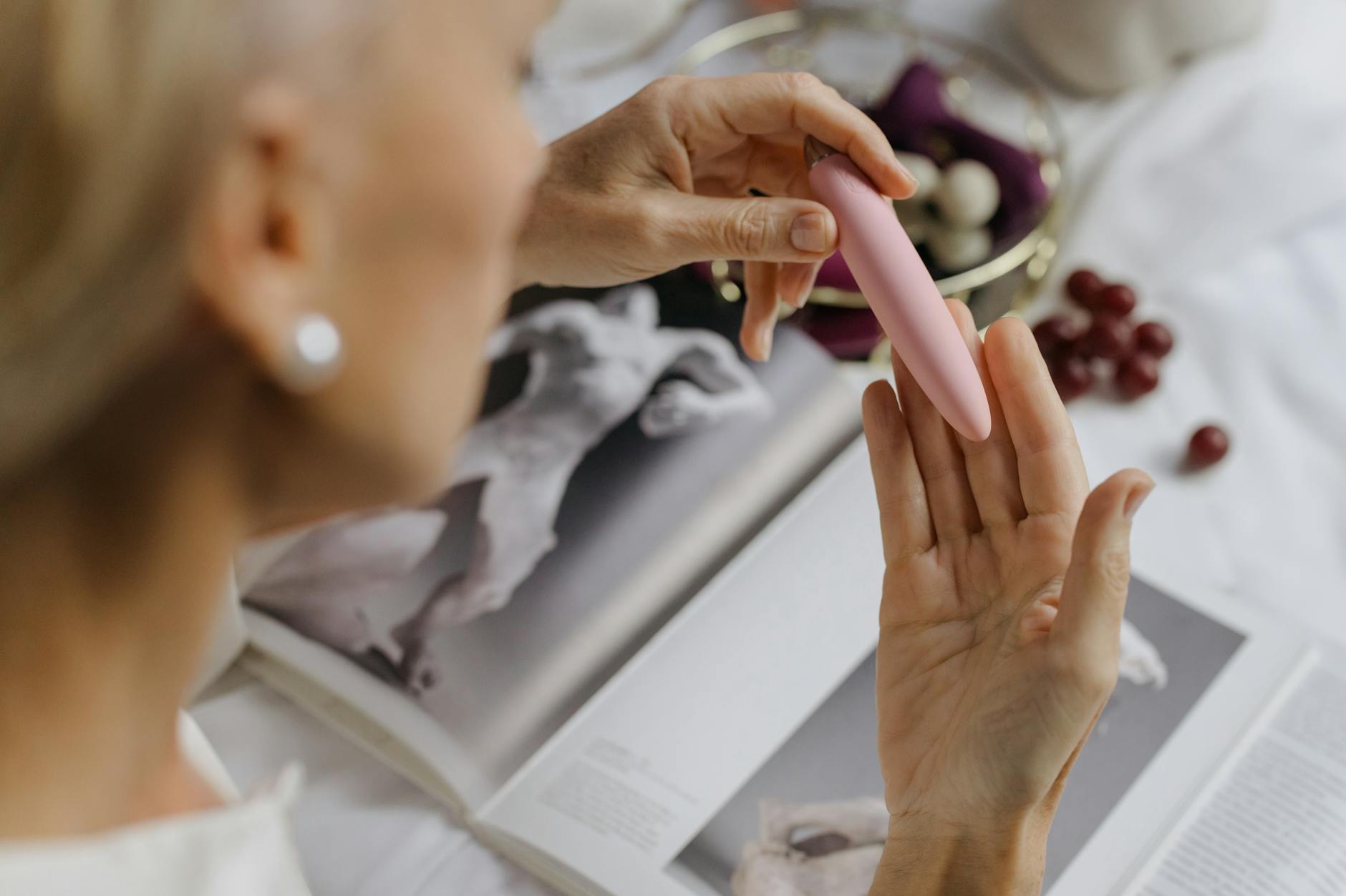 Woman holding Lemon clitoral vibrators in contemplative pose