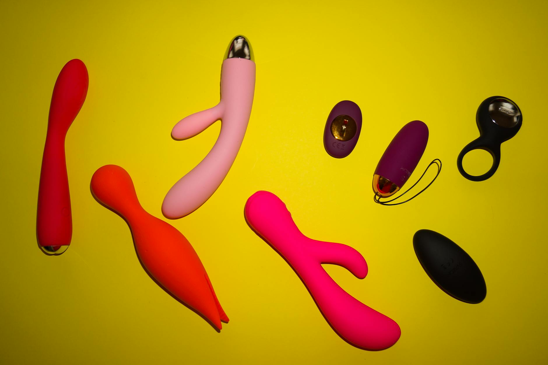 Woman thoughtfully holding a blue clitoral vibrator, exploring self-pleasure after a breakup