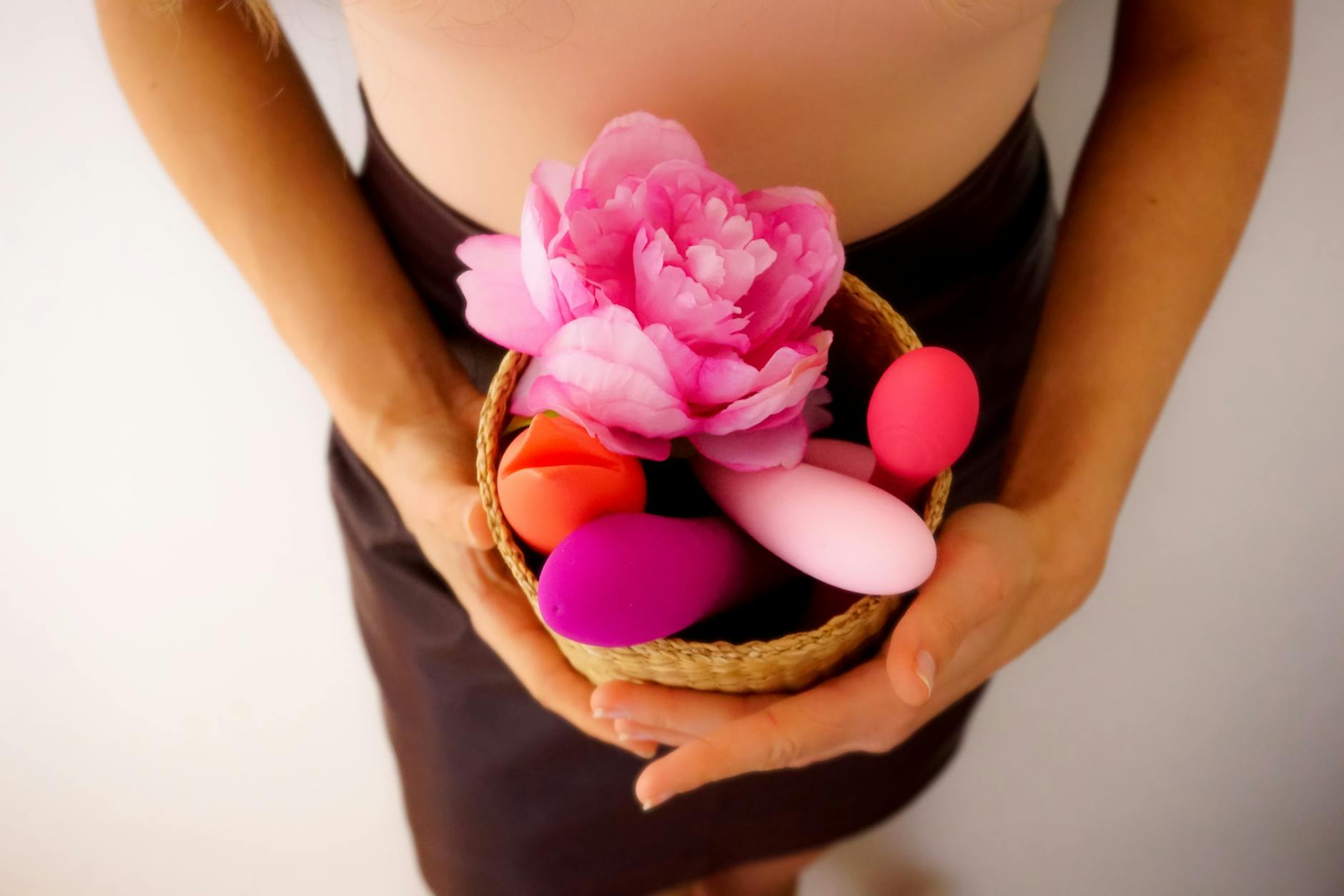 A collection of colorful clitoral vibrators and lemon sucker toys arranged in a basket