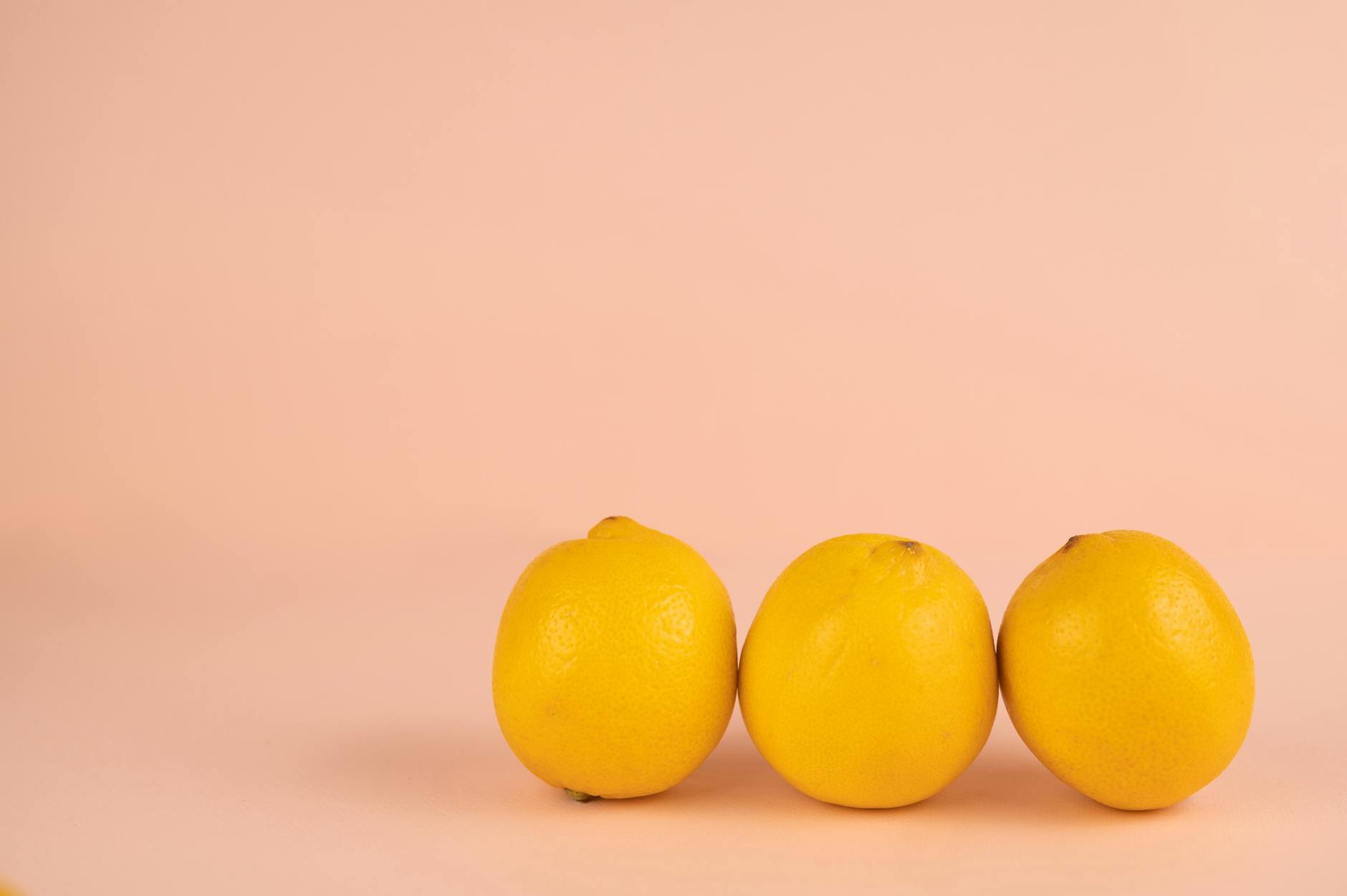 A blue clitoral vibrator surrounded by flowers and citrus slices on a bright yellow background